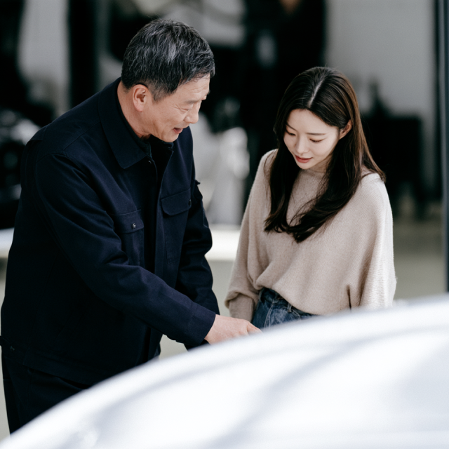 정비소에서 고객과 함께 차량을 살펴보는 정비사